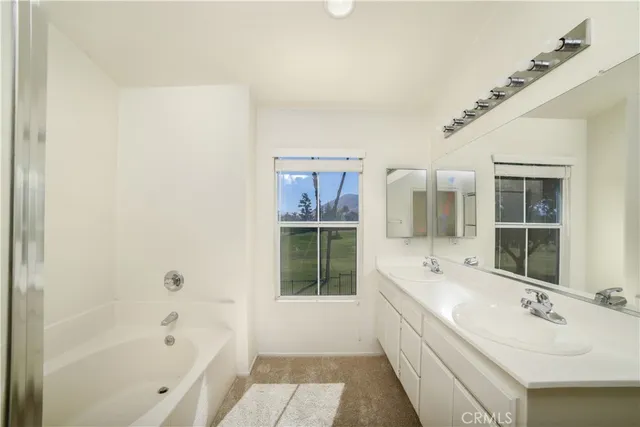 a bathroom with a bathtub sink and mirror