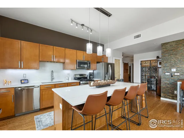 a kitchen with stainless steel appliances kitchen island granite countertop a sink and cabinets