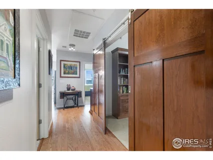 a open kitchen with furniture a refrigerator and wooden floor
