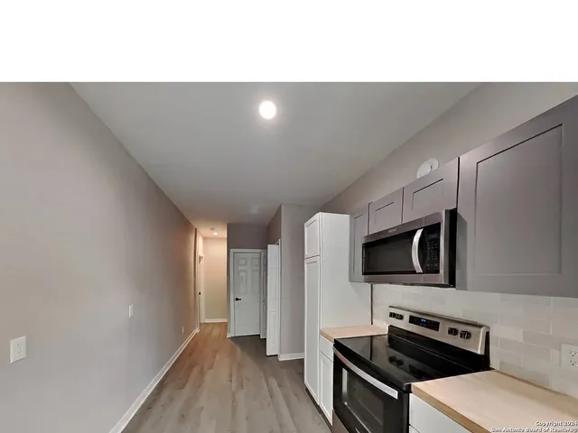 a kitchen with a refrigerator and a stove top oven