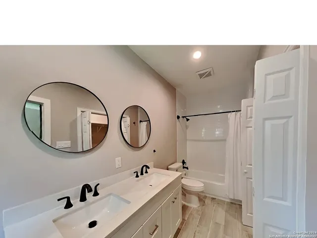 a bathroom with a double vanity sink and a mirror