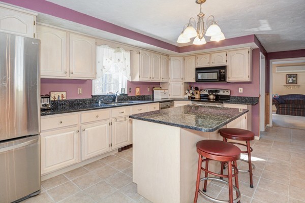 88 Mason Road Townsend, MA 01474 - Photo 15 of 30 a kitchen with stainless steel appliances granite countertop a sink a stove a refrigerator cabinets and chairs