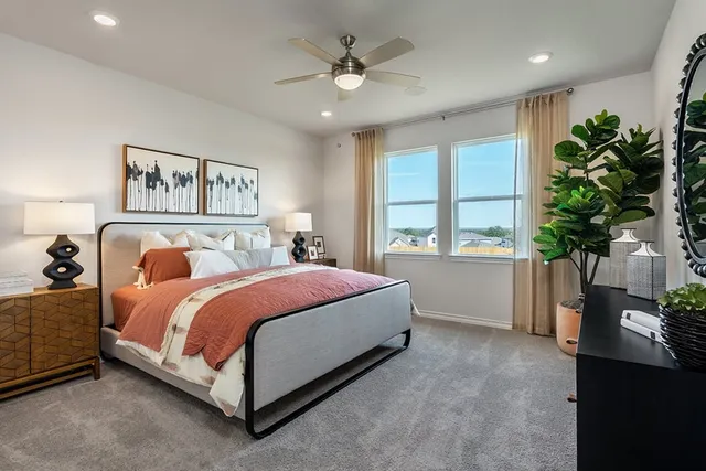 a spacious bedroom with a bed and a potted plant