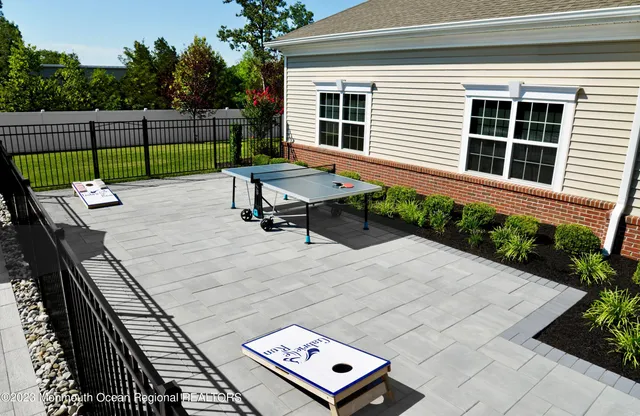 a view of a backyard with couches chairs and wooden fence