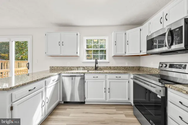 a kitchen with stainless steel appliances granite countertop a stove and a sink