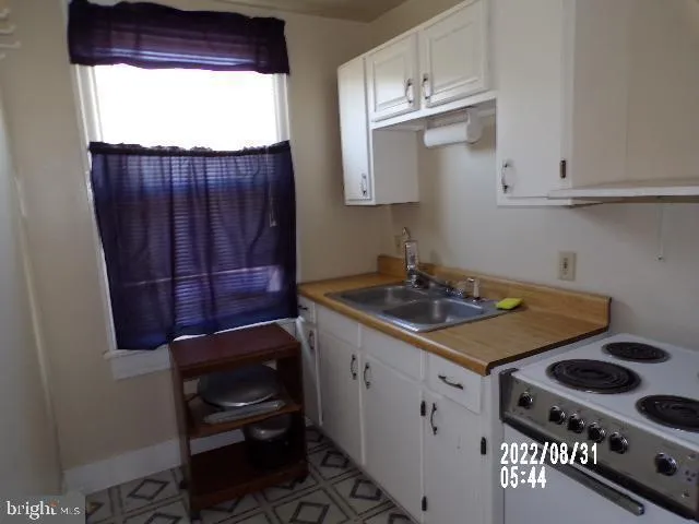 a kitchen with a stove a window and cabinets