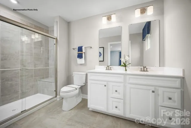 a bathroom with a double vanity sink toilet and shower