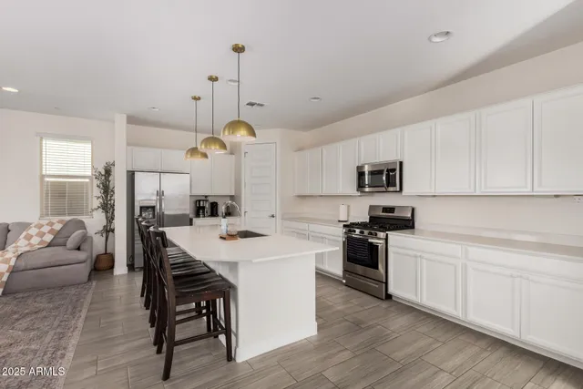 a open kitchen with white cabinets and stainless steel appliances