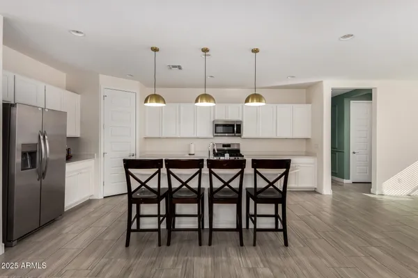 a kitchen with stainless steel appliances granite countertop a kitchen island hardwood floor and a sink