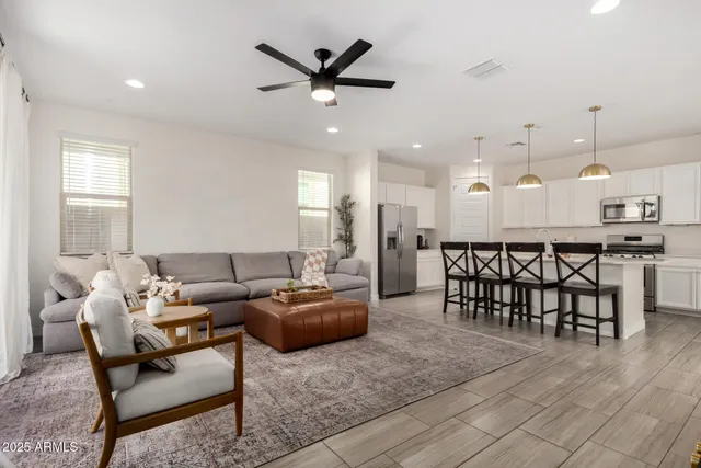a living room with furniture kitchen view and a chandelier