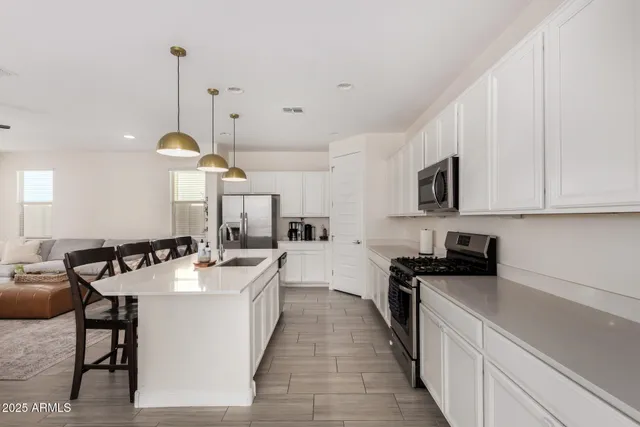 a kitchen with a sink a counter top space a stove and cabinets