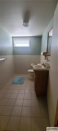 a room with a sink a toilet and mirror