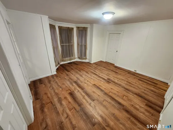 a view of empty room with wooden floor