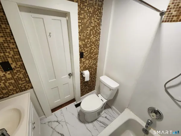 a white toilet sitting next to a bathroom sink and vanity