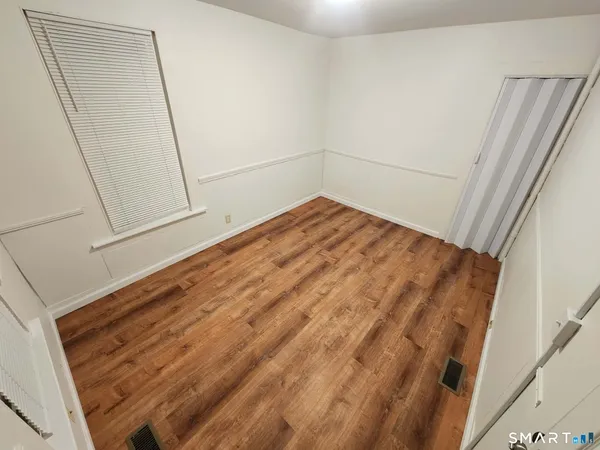 a view of empty room with wooden floor