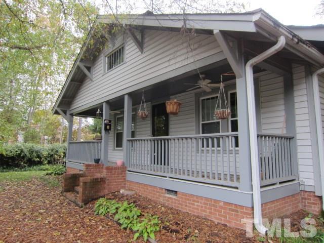 716 Crosby Road Durham, NC 27704 - Photo 14 of 17 a view of a white house with a small yard and a large tree