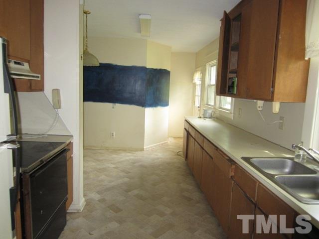 716 Crosby Road Durham, NC 27704 - Photo 10 of 17 a kitchen with stainless steel appliances granite countertop a sink stove and refrigerator