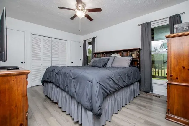 a bedroom with bed a bed and a refrigerator