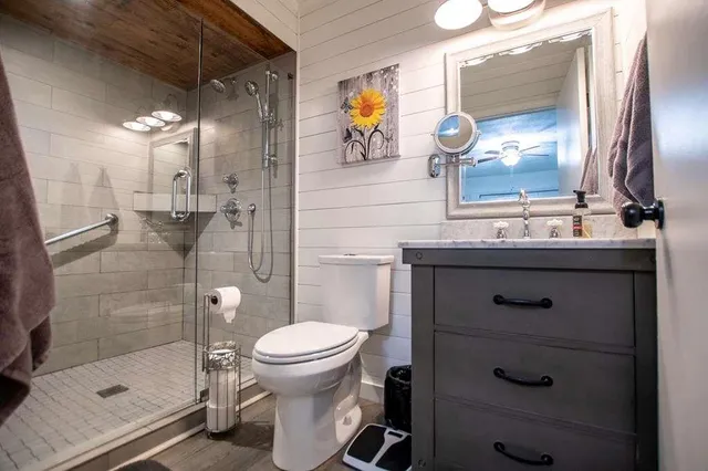 a bathroom with a sink a toilet and shower
