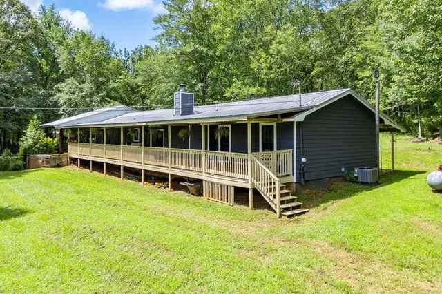 a view of a house with a yard and sitting area