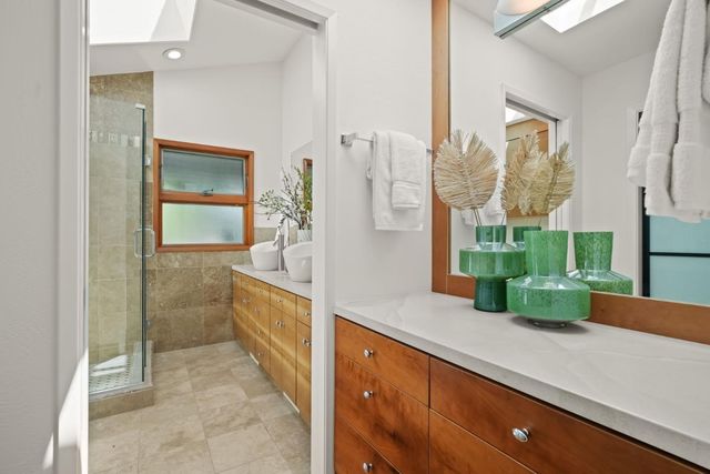 a bathroom with a sink a mirror and a shower