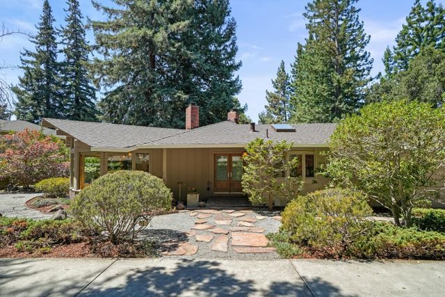 a view of a house with a yard and large tree