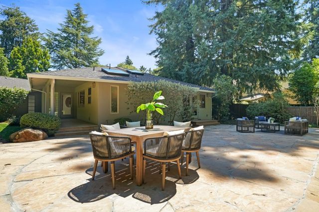 a view of backyard with outdoor seating a patio and plants