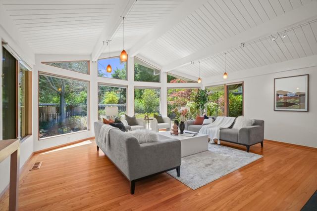 a living room with furniture and floor to ceiling windows