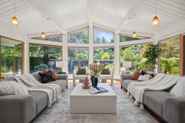 a bedroom with furniture and large windows