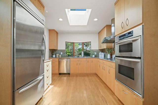 a kitchen with stainless steel appliances a stove a microwave and a refrigerator