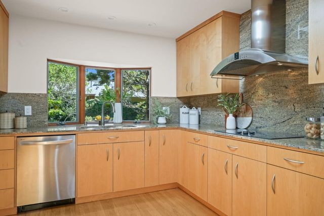 a kitchen with granite countertop white cabinets and a window