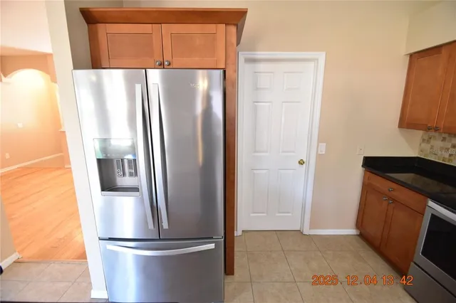 a metallic refrigerator freezer sitting in a kitchen