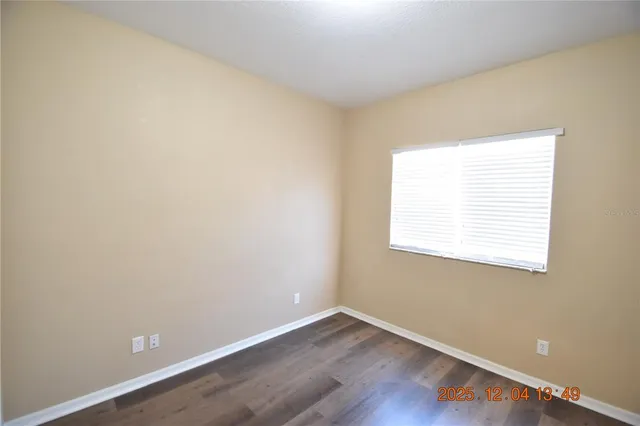 an empty room with wooden floor and a window