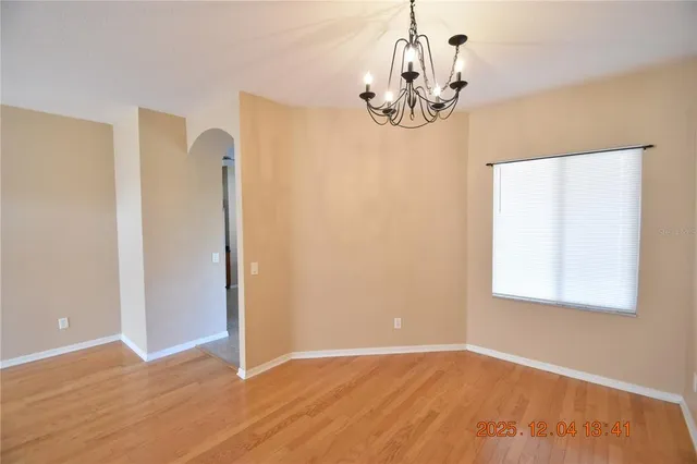 a view of a room with wooden floor and chandelier