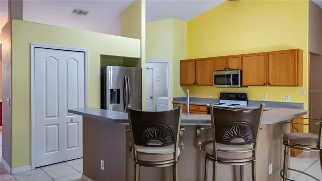 a kitchen with stainless steel appliances granite countertop a stove a sink and a refrigerator