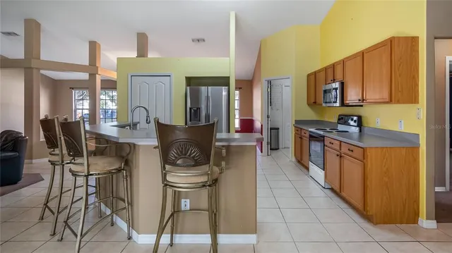 a kitchen with stainless steel appliances kitchen island granite countertop a stove a sink and a cabinets