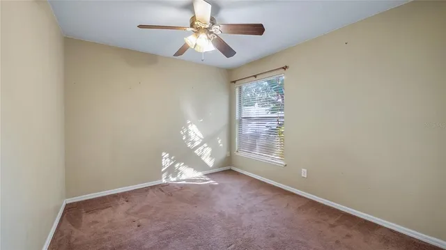 a view of a livingroom with a ceiling fan and window