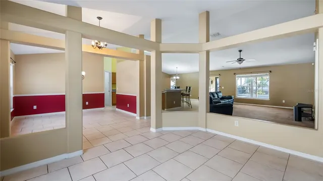 a view of a hallway with dining area and chandelier
