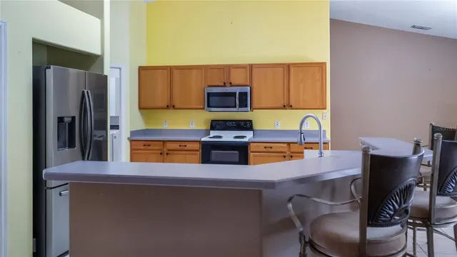 a kitchen with a table chairs refrigerator and microwave