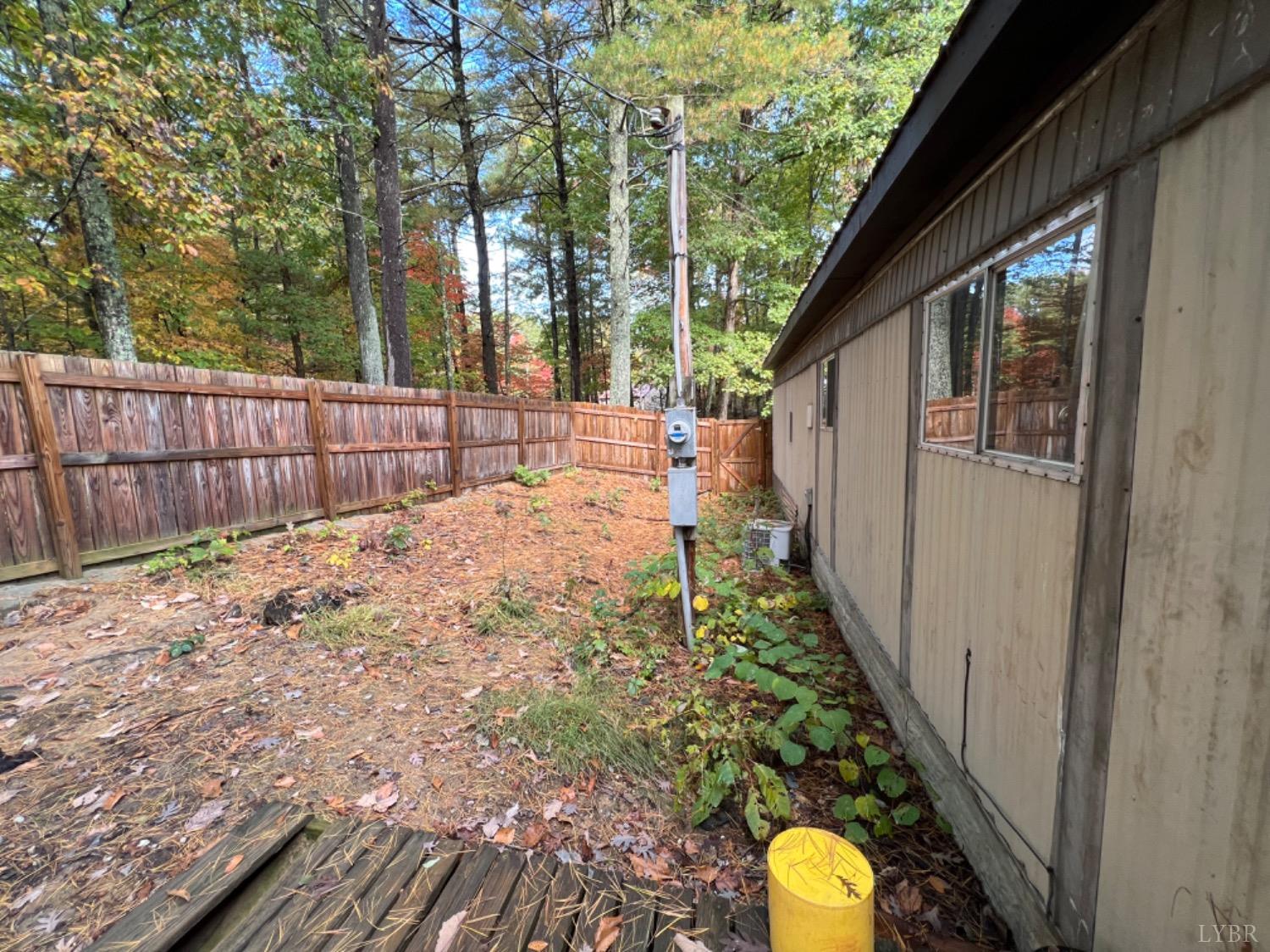 157 White Pine Drive Monroe, VA 24574 - Photo 12 of 13 a view of a backyard with large trees and wooden fence