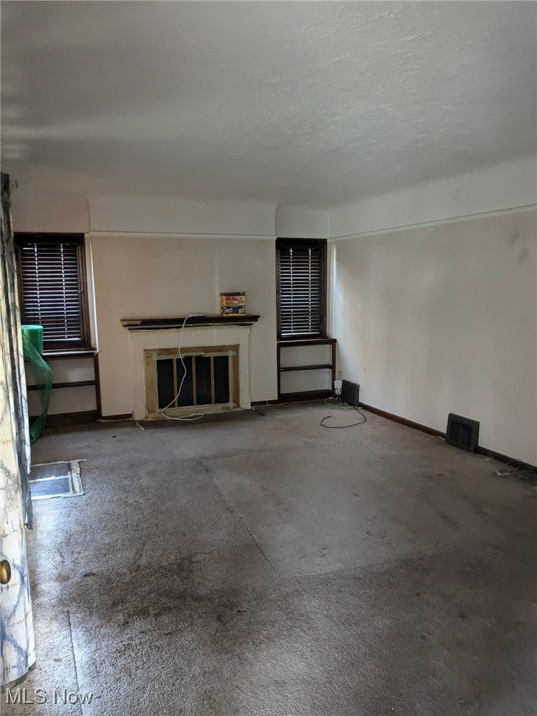 3643 Lindholm Road Cleveland, OH 44120 - Photo 3 of 9 Unfurnished living room with a high end fireplace, visible vents, a textured ceiling, and baseboards