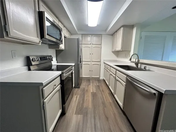 a kitchen with a sink a stove refrigerator and cabinets