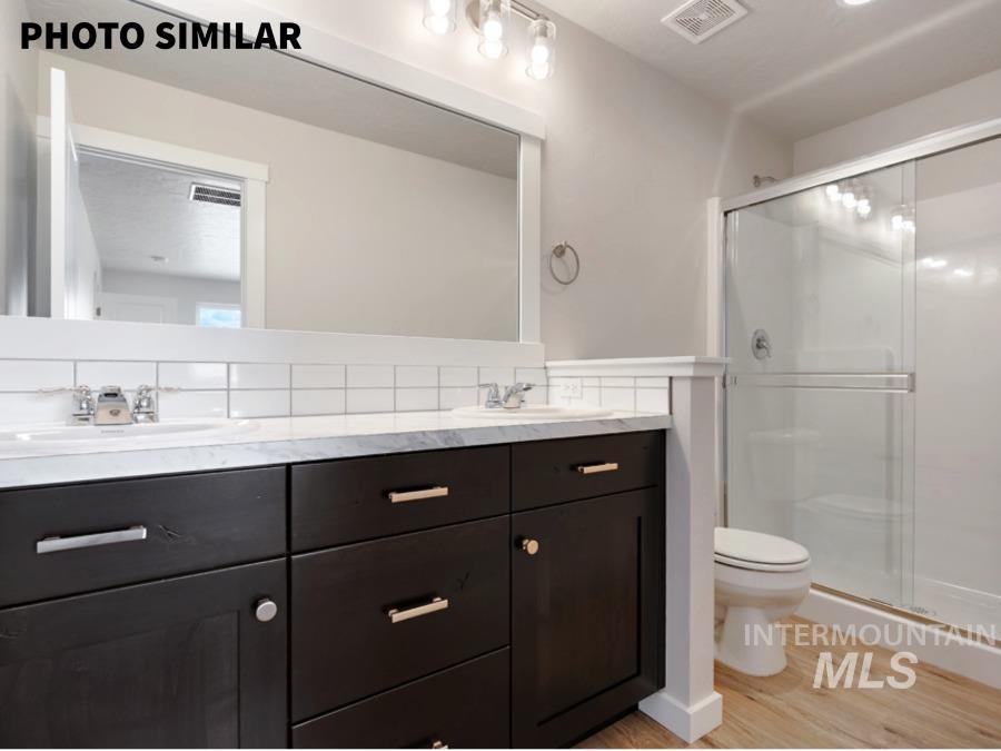 925 Twilight Weiser, ID 83672 - Photo 20 of 31 Bathroom featuring a dual vanity with dark wood-finish cabinetry, light-toned countertops, and dual undermount sinks