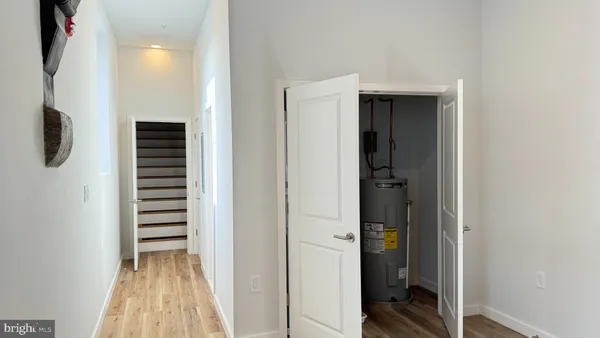 a view of a hallway with wooden floor and closet