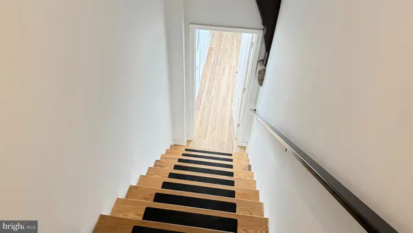 a view of a hallway with wooden floor and stairs