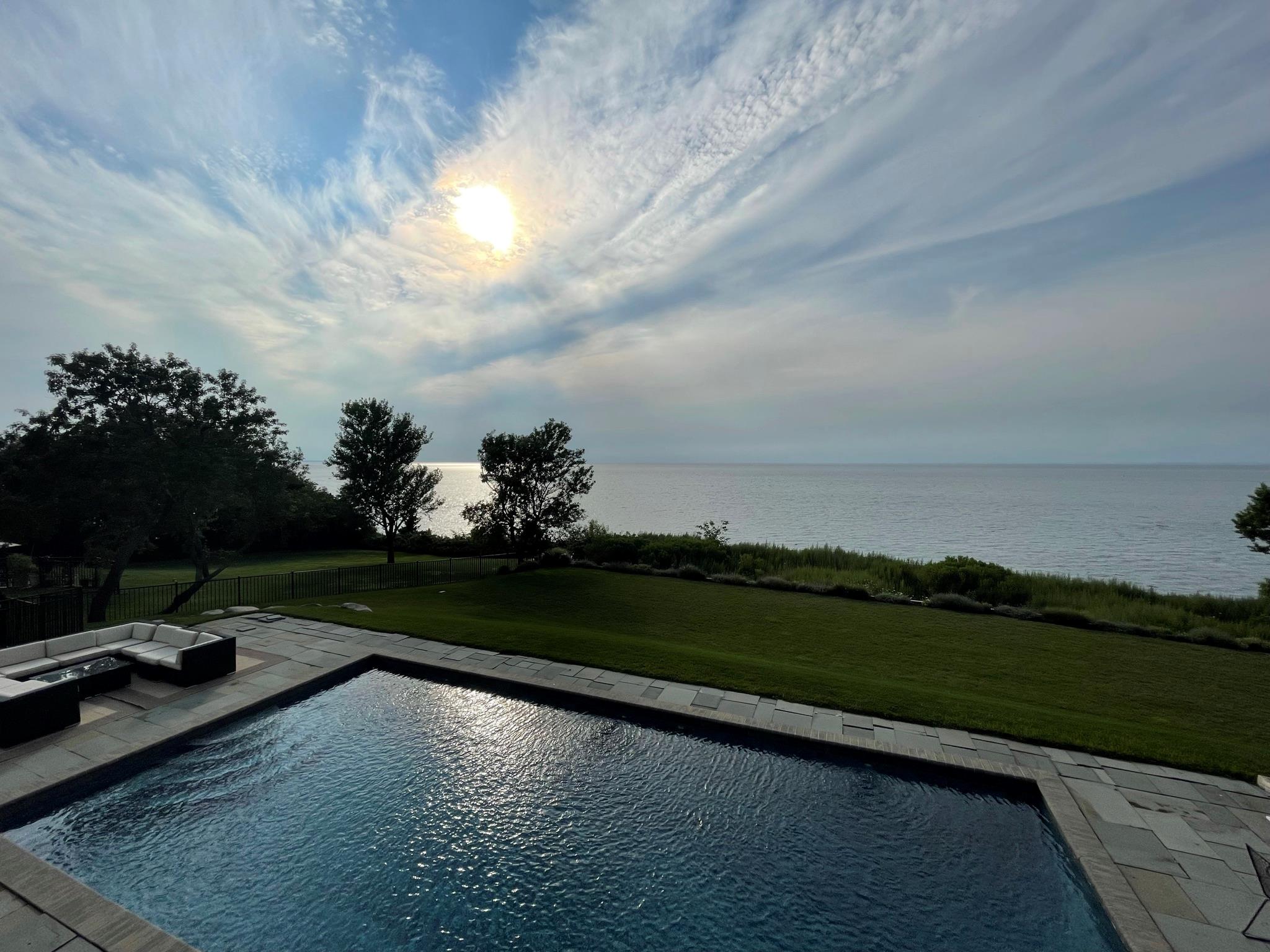 View of pool featuring a water view, a patio area, and a lawn