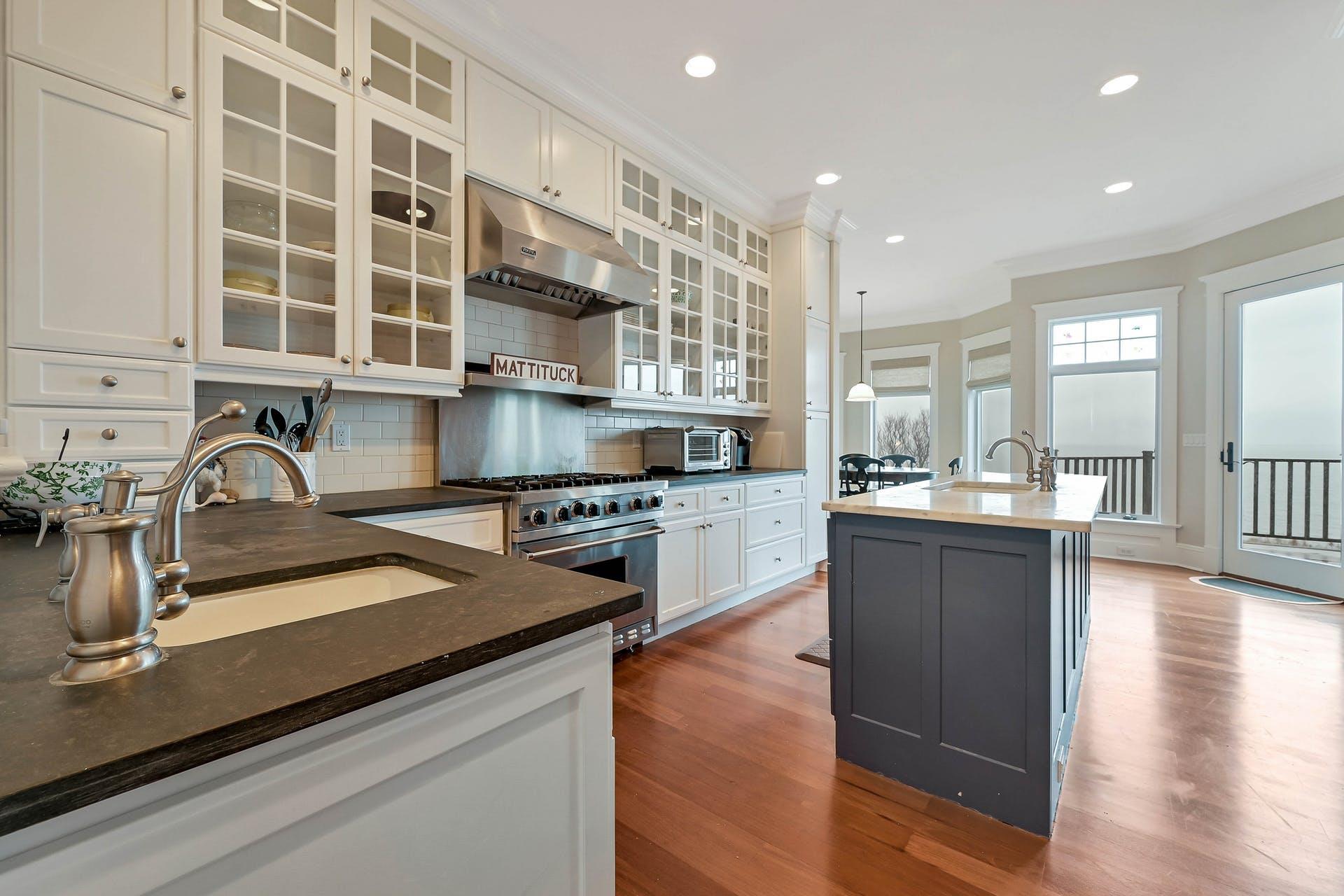 580 Lloyds Lane Mattituck, NY 11952 - Photo 15 of 30 Kitchen with sink, hanging light fixtures, a kitchen island with sink, high end range, and ornamental molding