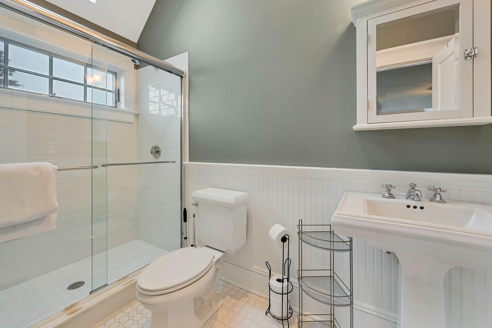 580 Lloyds Lane Mattituck, NY 11952 - Photo 27 of 30 Bathroom featuring tile patterned floors, sink, a shower with door, and toilet