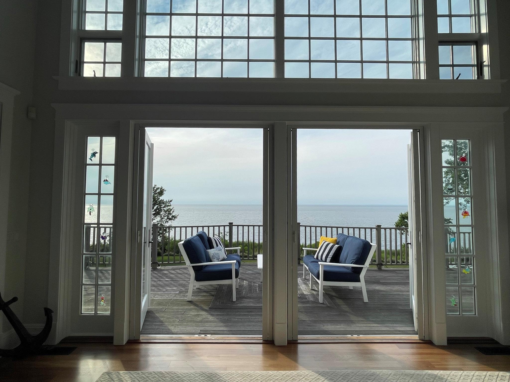 580 Lloyds Lane Mattituck, NY 11952 - Photo 4 of 30 Doorway featuring a water view, wood-type flooring, and a high ceiling