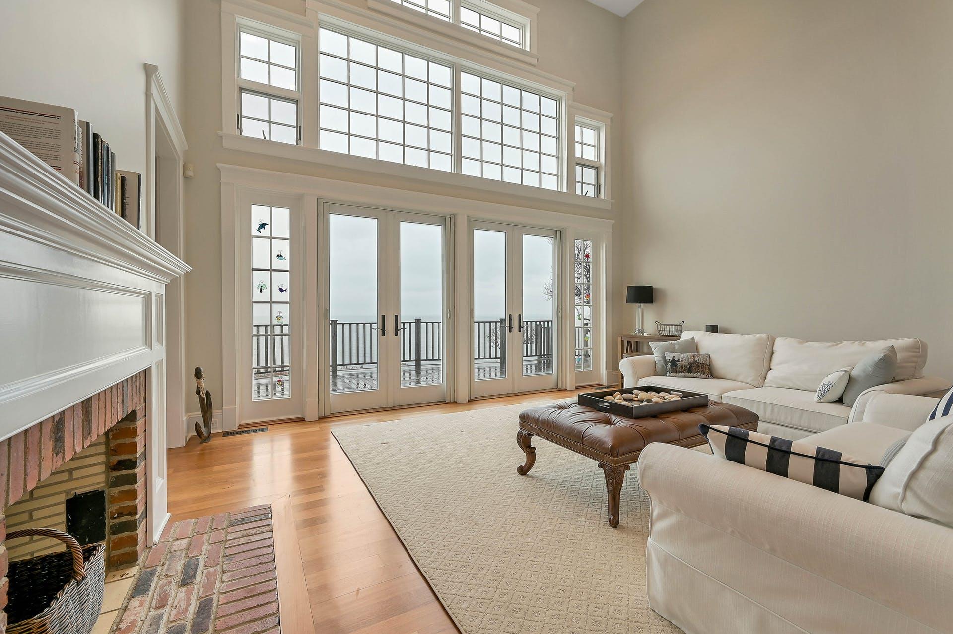 580 Lloyds Lane Mattituck, NY 11952 - Photo 9 of 30 Living room with a healthy amount of sunlight, a high ceiling, french doors, a fireplace, and light hardwood / wood-style floors